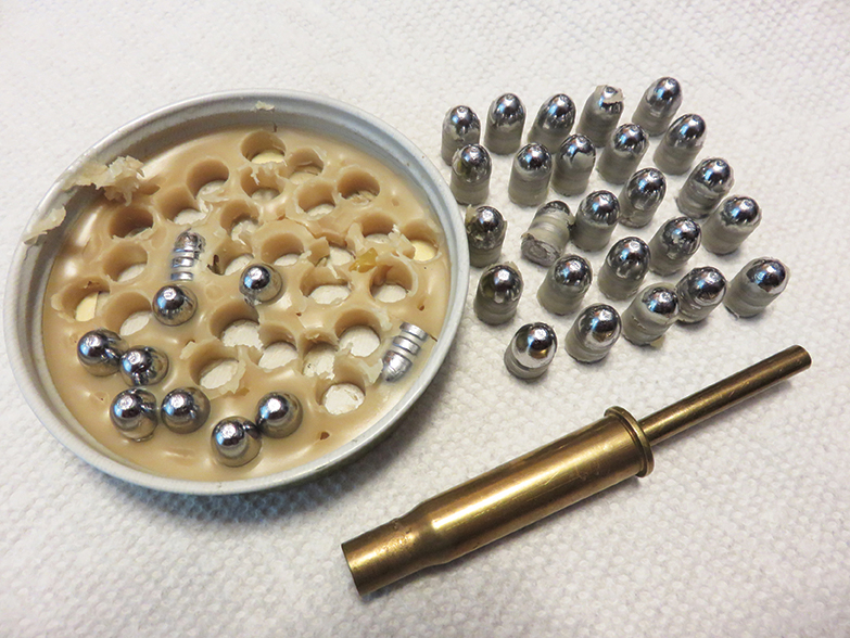 A metal jar lid, the 32 S&W “kake cutter” and some lubed bullets, ready to load.